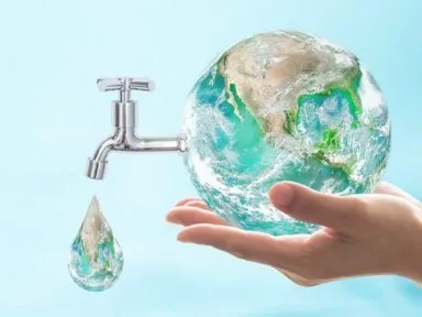 hand holding the world showing a nozzle of water