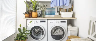 Laundry room with front load washer and dryer and hanging clean shirts. Promoting size water softener.