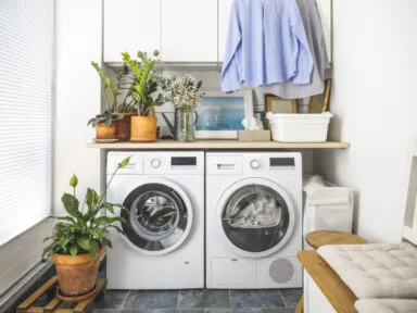 Laundry room with front load washer and dryer and hanging clean shirts. Promoting size water softener.