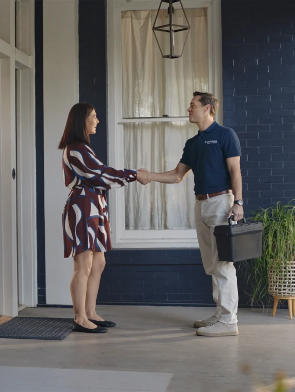 a man and woman shaking hands at the front doorstep