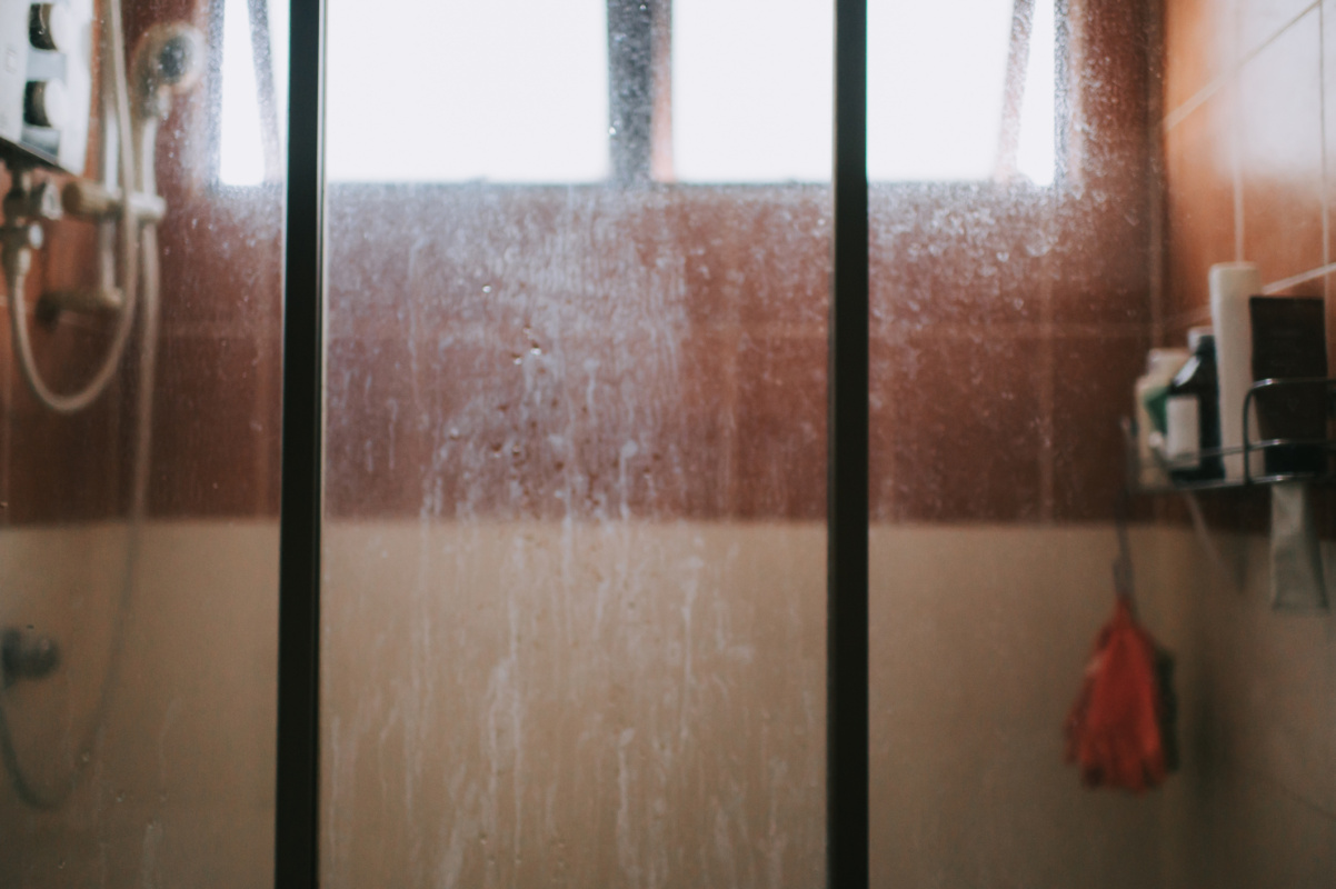 Close-up glass shower with hard water stains and spots