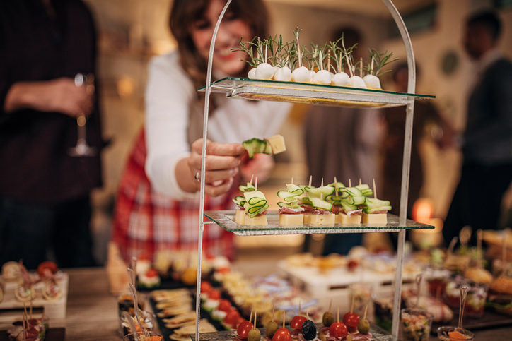 woman sampling finger foods at holiday party