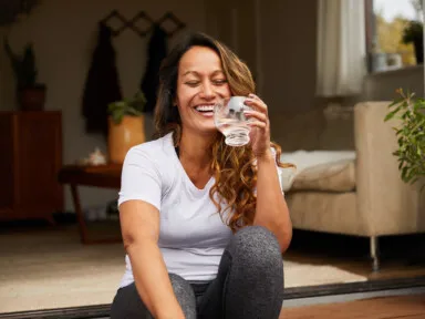 women sitting on porch step with a glass of water whole home water filtration