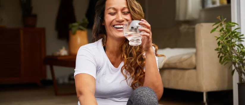 women sitting on porch step with a glass of water whole home water filtration