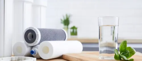 Three different water filters sitting on a kitchen counter.